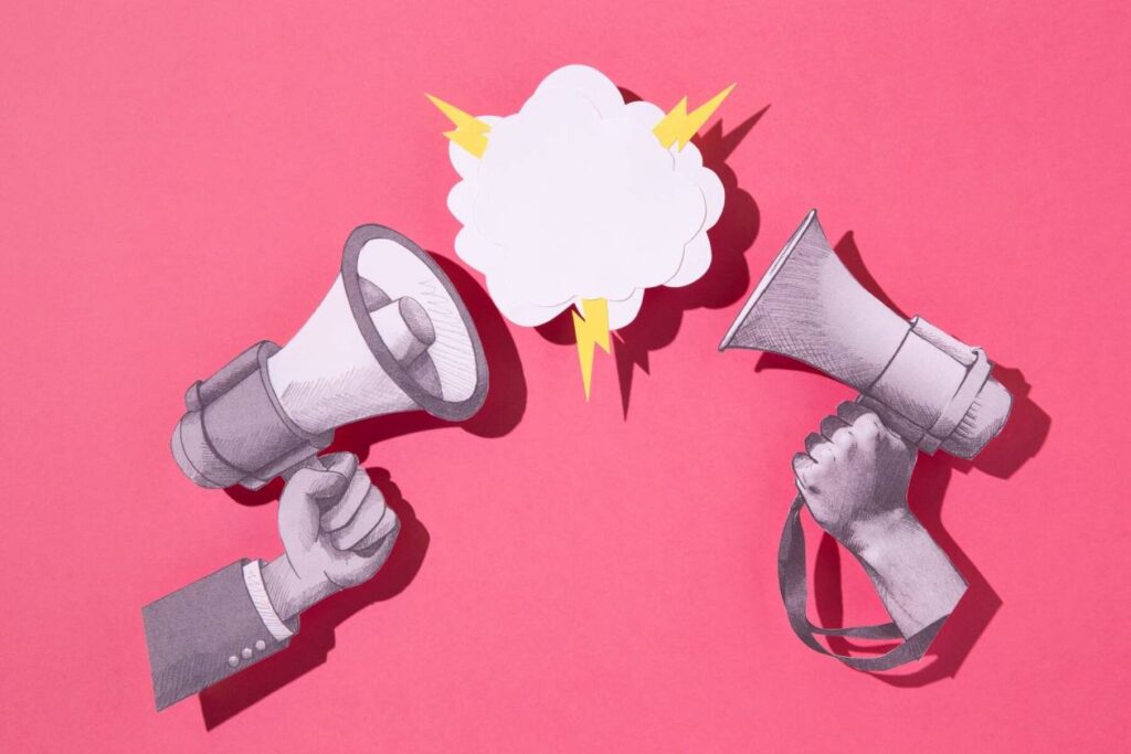 Two illustrated hands holding megaphones face each other on a pink background, with a speech bubble and yellow lightning bolts in the center—perfectly capturing the dynamic energy of Digital PR.